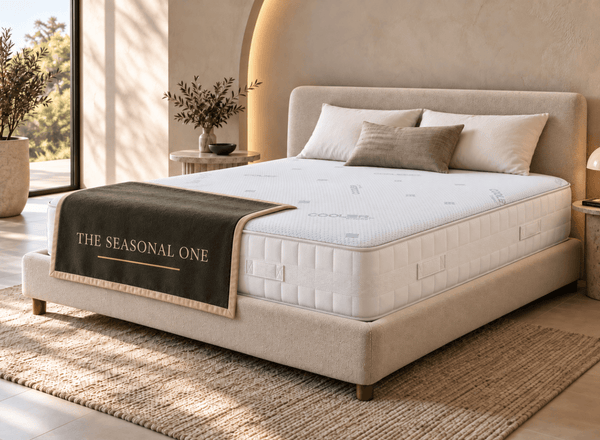 The Seasonal One mattress laid on top of an upholstered bed frame